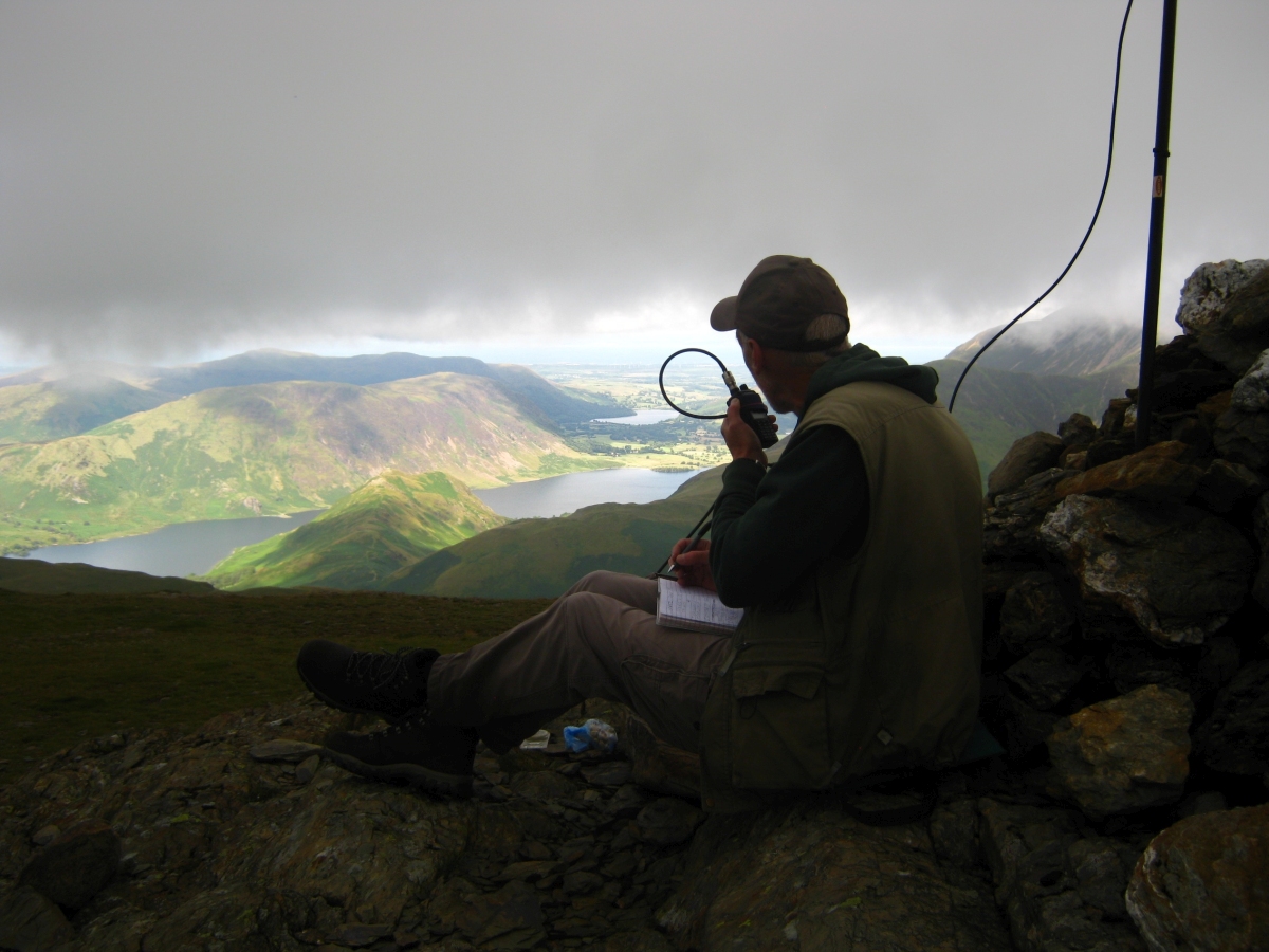 Richard operating portable on the fells with a handheld radio and mast
